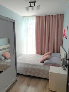a bedroom with a bed and a large mirror at Apartament Szary in Świnoujście
