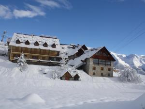 a building covered in snow in front of a mountain at Le Bataclan in Auron