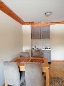 a small kitchen with a wooden table and chairs at Apartman 205- Aparthotel Vučko Jahorina private host 50m2 in Jahorina