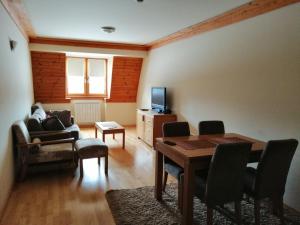 a living room with a table and a tv at Apartman 205 Aparthotel Vučko in Jahorina