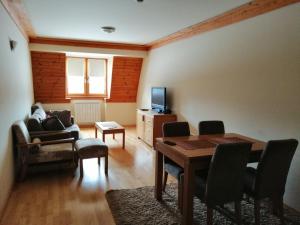 a living room with a table and a tv at Apartman 205- Aparthotel Vučko Jahorina private host 50m2 in Jahorina