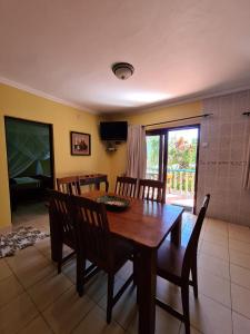 a dining room with a wooden table and chairs at Tri M Waves Lodge in Ponta do Ouro