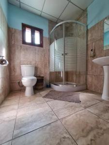 a bathroom with a toilet and a sink and a tub at Tri M Waves Lodge in Ponta do Ouro