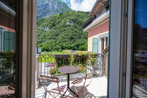 balcón con mesa y vistas a la montaña en Villa Bellaria, en Riva del Garda