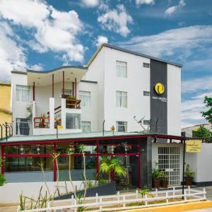 un grande edificio bianco con piante di fronte di Hostal Oro Negro a Talara