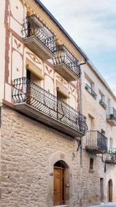 - un bâtiment avec des balcons sur le côté dans l'établissement Casa rural la Posada Terra Alta Matarraña, à Caseras