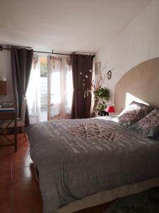 a bedroom with a large bed and a window at La Colombe in Tourrettes