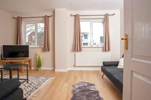 a living room with a couch and a tv at 3 Bed Townhouse Stafford in Stafford