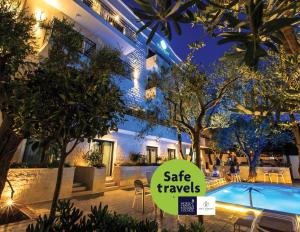 a hotel with a sale sign in front of a swimming pool at Hotel Harmony by Aycon in Petrovac na Moru