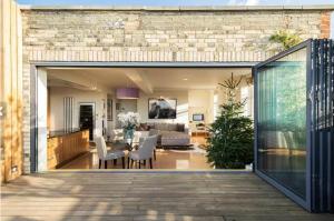 2 Bed Luxury apartment in Bayswater - amazing terrace views from 7th floor في لندن: غرفة معيشة وغرفة طعام مع باب زجاجي منزلق