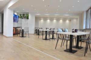 a conference room with tables and chairs in a building at Hotel Theotokos in Viggiano