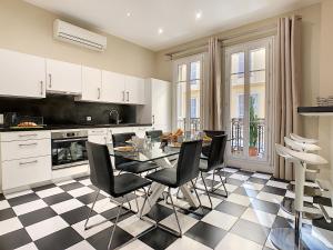 a kitchen with a table and black and white checkered floor at Nestor&Jeeves - PALAIS ARNULF - Central - Very close sea in Nice