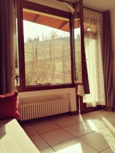 een slaapkamer met een raam met uitzicht op een veld bij BoscoBo - Relax & Natura in Bologna