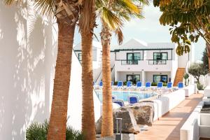 a resort with palm trees and a swimming pool at Hotel Pocillos Playa, solo Adultos in Puerto del Carmen