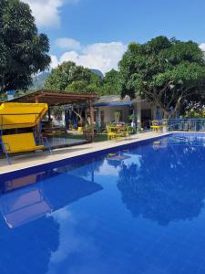 a swimming pool with blue water in front of a house at El Piropo in La Vega