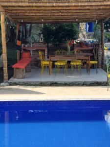 a patio with a table and chairs next to a pool at El Piropo in La Vega