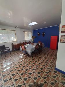 a dining room with a table and chairs and a blue wall at El Piropo in La Vega