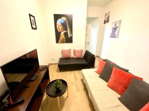 a living room with a couch and a television at Сarnot Apartments ZOO Area in Antwerp