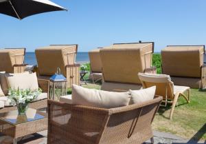 
a patio area with chairs, tables and umbrellas at Hotel Miramar in Westerland
