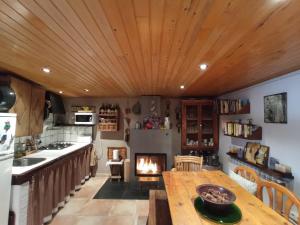 a kitchen with a wooden ceiling and a fireplace at El Paller Urús Cerdanya in Urus