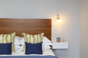 a bedroom with a bed with a wooden headboard and pillows at Belgravia Apartments in London