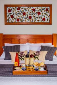 a tray with food and drinks on a bed at Chalés Estrela da Mantiqueira in Monte Verde