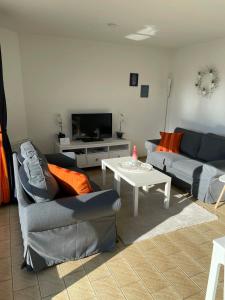 a living room with couches and a table and a tv at Sea 2 in Middelkerke