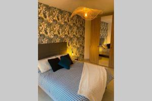 ein Schlafzimmer mit einem Bett mit einer blauen und weißen Decke in der Unterkunft Deux pieces Moderne et Chaleureux in Saint-Laurent-du-Var