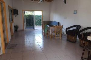 ein Wohnzimmer mit einem Tisch, Stühlen und einer Tür in der Unterkunft C4 casa segundo nivel peñita con alberca privada in La Peñita de Jaltemba