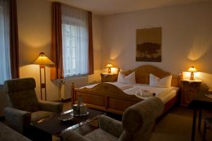 um quarto de hotel com uma cama, uma mesa e cadeiras em Landhotel Kertscher-Hof em Schmölln
