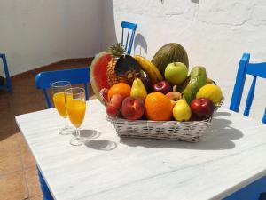 a basket of fruit on a table with two glasses of juice at 3 bedrooms house at El Golfo Lanzarote 500 m away from the beach with furnished terrace and wifi in El Golfo