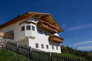 une maison blanche avec des boîtes de fleurs sur une clôture dans l'établissement Ferienwohnungen Zeppenhof, à Santa Valburga