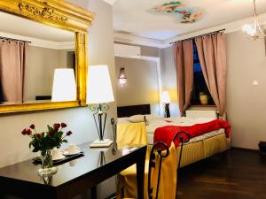 um quarto com uma cama, uma secretária e um espelho em Restauracja - Hotel Mocca D'oro em Mikolów