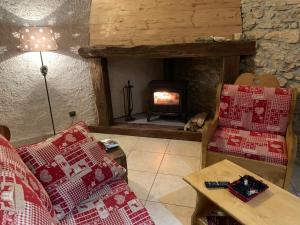 a living room with a couch and a fireplace at L'écho des Artois in Uzelle