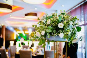 a large flower arrangement on a table in a restaurant at Hotel Modus in Łaziska Górne