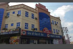 un gran edificio con ventanas azules en una calle en HOTEL SITI CASTLE, en Jalandhar