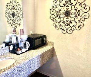 a microwave sitting on a counter next to a sink at Best Inn Texas in Levelland