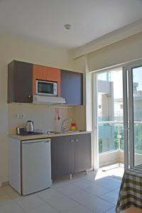 a kitchen with a sink and a microwave at Bristol Sea View Apartments in Kos Town