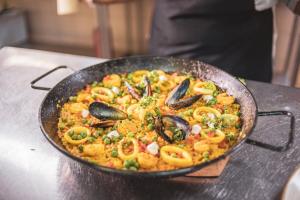 una sartén de alimentos con mejillones en una mesa en Aura Hotel Barú, en Barú