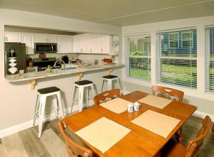 una cucina con un tavolo e sedie in legno in una stanza di Harts Cottage a Lillian