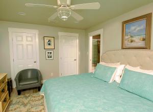 una camera da letto con un letto e un ventilatore a soffitto di Harts Cottage a Lillian