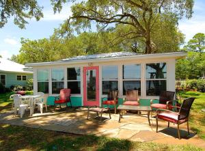 una veranda protetta con sedie e un tavolo di Harts Cottage a Lillian