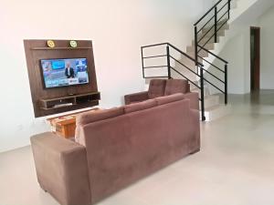 ein Wohnzimmer mit 2 Sofas und einem TV in der Unterkunft Sunny in Florianópolis