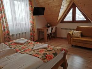 um quarto com uma cama, um sofá e uma janela em Kłabuk em Białka Tatrzanska