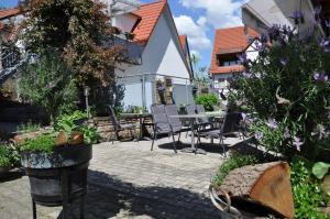 Un patio con mesa y sillas y flores. en Löwen Hotel & Restaurant, en Wendlingen am Neckar