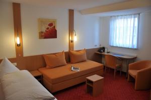 una sala de estar con un sofá y una mesa en Löwen Hotel & Restaurant, en Wendlingen am Neckar