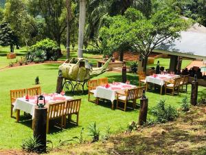 a restaurant with tables and chairs in the grass at Madi a Thavha Mountain Lodge in Louis Trichardt