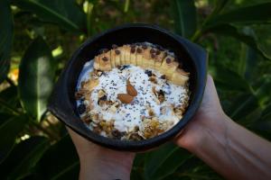 a person holding a bowl of food with a waffle at Origen Hostel in El Zaino