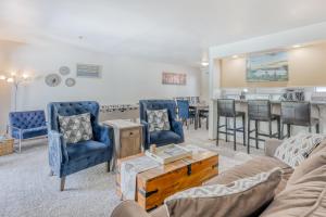 una sala de estar con sillas azules y un bar en South Star Pines Retreat, en Stateline