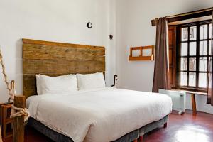 ein Schlafzimmer mit einem großen weißen Bett und einem Fenster in der Unterkunft Sereno Art Hotel in San Cristóbal de las Casas